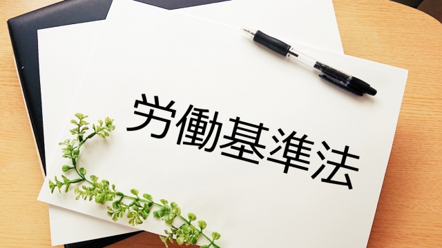 Một cuốn sách luật pháp và một cái búa thẩm phán trên bàn gỗ